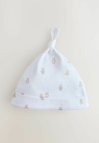 White knit baby hat featuring a knotted top, decorated with small teddy bear patterns and light blue stars. Smooth texture and soft material.