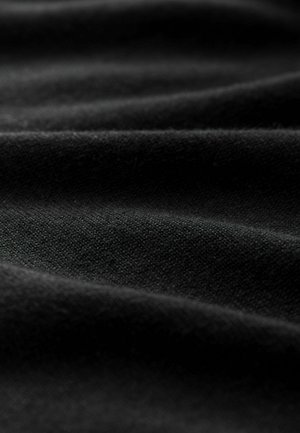 Juoda medžiaga su minkšta tekstūra, pasižyminti subtiliomis raukšlėmis ir lygiu paviršiumi, sudaryta iš tankiai austų pluoštų.