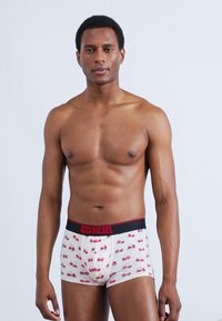 Λευκά μποξεράκια με κόκκινο και ροζ μοτίβο αυτοκινήτου, μαύρη ελαστική μέση με λογότυπο "DIESEL", μαλακό ύφασμα, εφαρμοστή σχεδίαση.