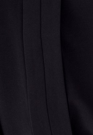 Schwarzer Stoff mit glatter Textur, der subtile Nähte und Falten aufweist. Das Design ist minimalistisch, ohne sichtbare Muster oder Verzierungen.
