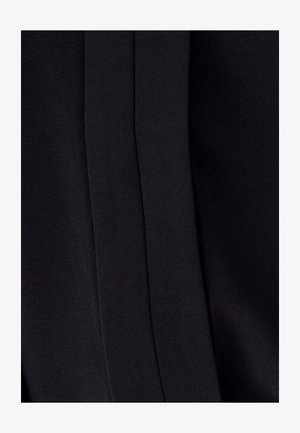 Tejido negro con una textura suave, que presenta costuras y pliegues sutiles. El diseño es minimalista, sin patrones o adornos visibles.