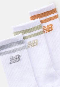 Tre par vita ankelsockor med ribbad textur och färgade ränder samt "NB"-logotyper i grått, olivgrönt och orange nära toppen.