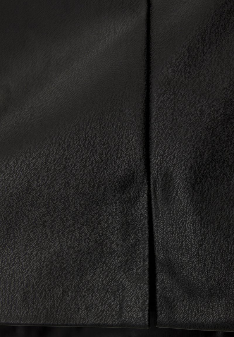 Tessuto di pelle nera con una superficie texturizzata, caratterizzato da una cucitura verticale al centro. Nessun hardware visibile o dettagli aggiuntivi.