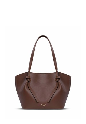 Brown leather tote bag with a pronounced shape, featuring tied accents on the sides and gold logo at the base. Smooth texture.