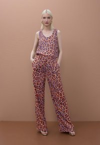 Conjunto de top de tirantes y pantalones de pierna ancha con estampado de leopardo en coral, con manchas moradas y negras, con bolsillos y un ajuste relajado.