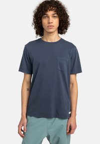 Navyblaue Baumwoll-T-Shirt mit Rundhalsausschnitt und kurzen Ärmeln. Verfügt über eine Brusttasche auf der linken Seite und eine lockere Passform.