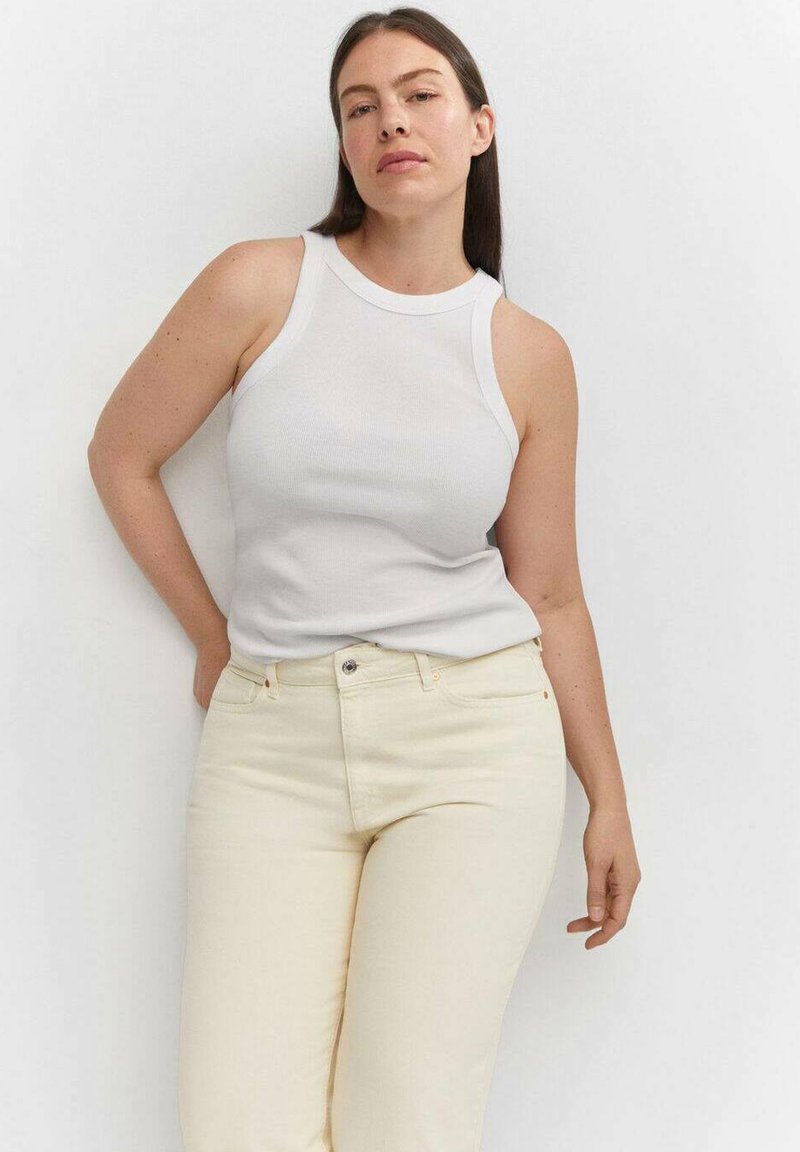 Weißes geripptes Tanktop mit rundem Ausschnitt, kombiniert mit hellbeigen, hochgeschnittenen Jeans im klassischen Fünf-Taschen-Design.