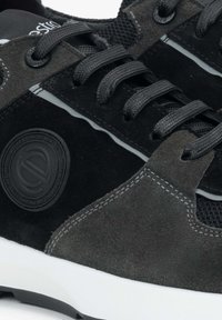 Czarne sneakersy z połączeniem zamszu i materiału siatkowego, okrągłymi sznurówkami, rzeźbioną białą podeszwą środkową oraz z teksturowanym czarnym detalem logo.