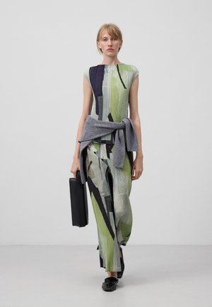 Multicolored, pleated outfit featuring green, navy, and black design; paired with a light gray cardigan tied at the waist and black briefcase.
