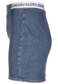 Falda de mezclilla con cintura alta y banda elástica blanca con el logo "CALVIN KLEIN JEANS". Presenta un diseño entallado y un dobladillo por encima del muslo medio.