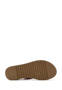 Suela de zapato con un diseño texturizado y estriado en goma marrón. Forma plana adecuada para tracción y estabilidad. Bordes suaves, detalles mínimos.