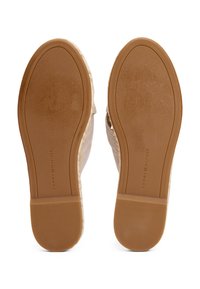 Sandale à tige tissée beige, dotée d'une semelle en caoutchouc marron à rainures avec le logo "TOMMY HILFIGER" embossé sur le côté.