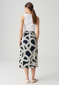 Jupe midi légère bleu marine avec un motif géométrique crème, dotée d'une taille élastique et d'une silhouette fluide.