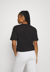 Puma CROPPED LOGO TEE - Apdrukāts T-krekls - puma black