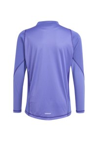 Paarse sportshirt met lange mouwen gemaakt van ademend meshweefsel. Voorzien van een ronde kraag en contrasterende stiksels langs de mouwen.