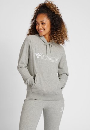 Grijze hoodie en joggingset van zacht materiaal. Bevat een voorzak, verstelbare trekkoordkap, en een wit logo op de borst.