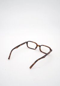 Ορθογώνια γυαλιά οράσεως με σκελετό από χελώνα, πλήρους περιγράμματος και ελαφρώς καμπύλες βραχίονες, τοποθετημένα πάνω σε λευκή επιφάνεια.