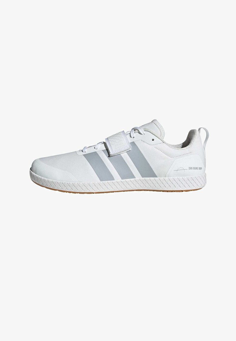 Chaussure de sport blanche avec des bandes grises, lacets et bride à scratch, semelle texturée, et texte "Zero Degree Drop" près du talon.