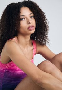 Débardeur à dégradé coloré, passant d'un rose vif à un violet profond. Tissu lisse et extensible, avec des bretelles étroites et une coupe ajustée.