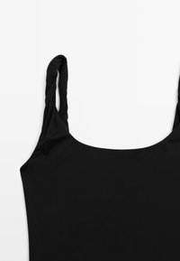 Svart ärmlös topp med vridna remmar och vid halsringning, med ett mjukt, stretchigt tyg och en enfärgad design.