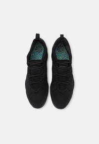 Svarta träningsskor med ovandel i texturerad stickad design, elastiskt snörningssystem och innersula med flerfärgat mönster. Platta gummisulor.