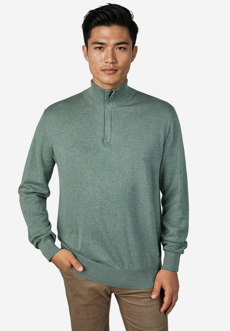 Hellgrüner Strickpullover mit hohem Kragen, halb offenem Reißverschluss, gerippten Bündchen und Saum. Glatte Textur, figurbetontes Design.