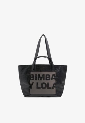 Melna tote soma, kas izgatavota no spīdīga, teksturēta materiāla. Iezīmē lieli melni burti "BIMBA Y LOLA" uz matēta pelēka paneļa. Divas rokas.