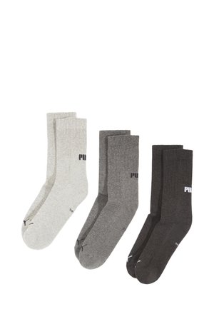 Trois paires de chaussettes Puma en gris clair, gris moyen et gris foncé, disposées côte à côte sur un fond blanc.