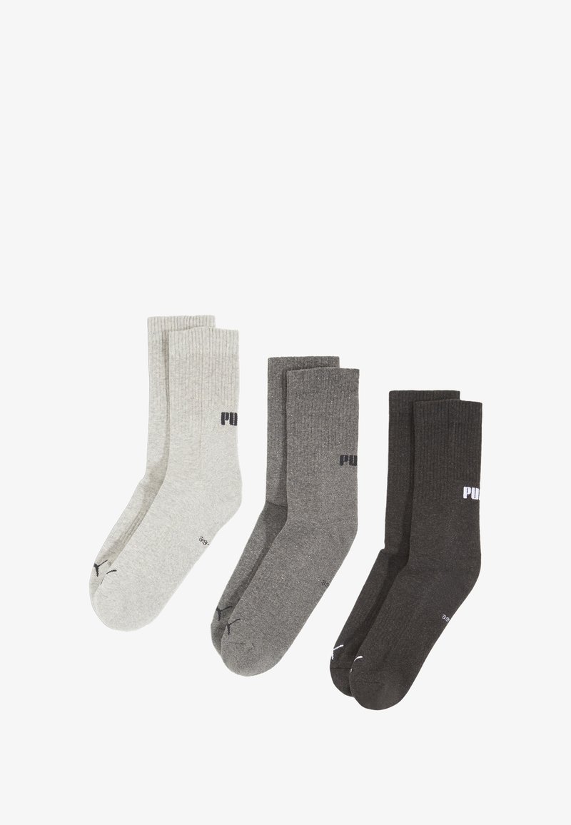 Trzy pary skarpetek Puma w kolorach jasnoszarym, średnioszarym i ciemnoszarym, ułożone obok siebie na białym tle.