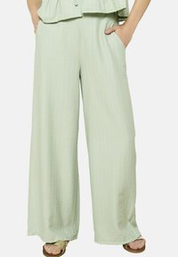 Svetlozeleni široki hlače iz teksturirane tkanine, z navpičnimi črtami, dvema stranskima žepekoma in sproščenim krojem.