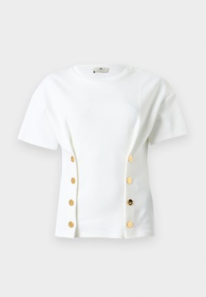 Λευκό t-shirt με κοντά μανίκια από μαλακό ύφασμα, με διακοσμητικά χρυσά κουμπιά σε κάθε πλευρά και κλασικό στρογγυλό λαιμόκοψη.