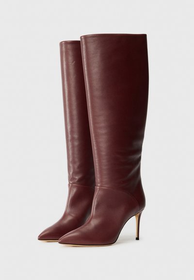 Bottines en cuir bordeaux hauteur genou avec un bout pointu et un talon fin et haut. Texture lisse avec un design de tige ajustée.