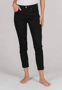 Zwarte stretch denim jeans met een aansluitend ontwerp, cropped lengte, vijf-pocket styling en zilverkleurige hardware details.