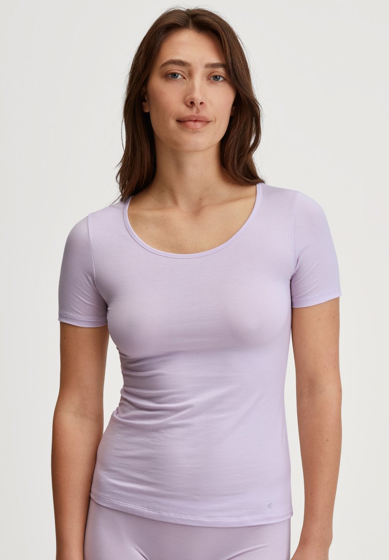 Lichtpaarse, kortärmige t-shirt gemaakt van zachte stof. Heeft een ronde halslijn en een getailleerde pasvorm, met minimale stiksels en geen zichtbare patronen.