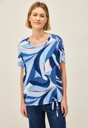Haut bleu à manches courtes orné d'un motif de feuilles dans différentes nuances de bleu, avec des accents roses et un détail de nouage sur le côté pour le style.