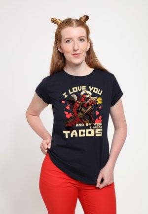 Mørkeblå T-shirt med grafisk design og tekst: "JEG ELSKER DIG, OG MED DIG MENER JEG TACOS," der viser to figurer i livlige farver.