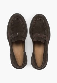 Bruine suède instapschoenen met een moccasinontwerp, voorzien van decoratieve stiksels, een opgevouwen leren band en een klein metalen accent.