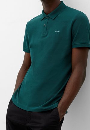 Teal polo shirt lavet af tekstureret stof, med en klassisk krave, tre knapper og et lille hvidt logo på venstre bryst.