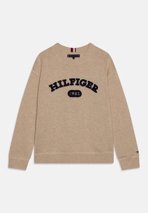 Beige trui met een ronde halslijn, voorzien van een donkerblauwe "HILFIGER 1985" logo. Ribgebreide manchetten en zoom, zachte textuur.
