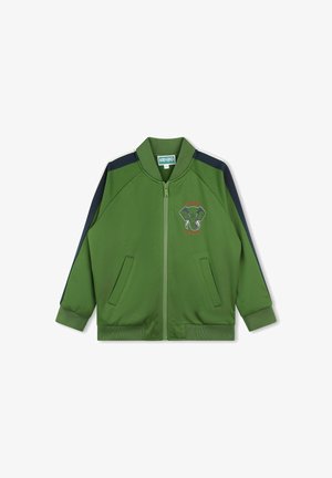 Giacca verde con cerniera e dettagli blu navy, tasche frontali, polsini a coste e grafica di elefante ricamata. Realizzata in tessuto leggero e liscio.