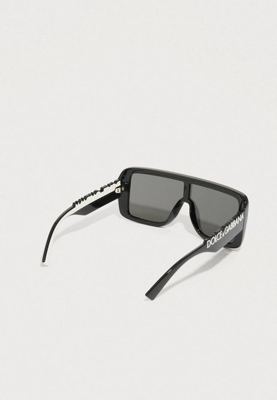 Mustad ristkülikukujulised päikeseprillid hallide läätsedega, millel on tekstureeritud sang ja valge brändi logo külgedel. Valmistatud läikivast materjalist.