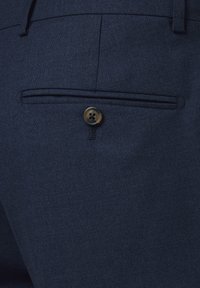 Ciemnoniebieska tkanina o fakturowanej powierzchni, z tylną kieszenią zabezpieczoną okrągłym, ciemnym guzikiem oraz subtelnym przeszyciem.