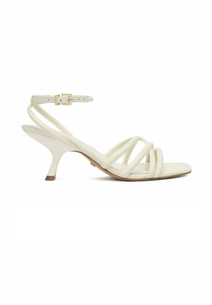 Sandalo bianco con cinturini sottili, tacco alto, punta quadrata, fibbia alla caviglia e tacco curvo di media altezza.