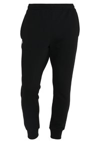 Pantalones de chándal negros hechos de una tela suave, con cintura elástica, diseño de pierna ajustada y un pequeño logo en el muslo izquierdo.