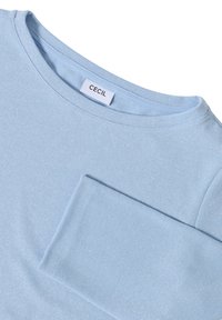 Helles blaues Langarmhemd mit rundem Ausschnitt, subtil schimmerndem Stoff und einer Brusttasche, innen am Kragen mit dem Etikett "Cecil".