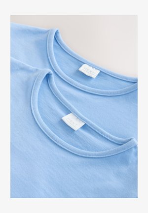 Par plavih pamučnih majica s okruglim izrezom, jednostavnog dizajna i vidljivim oznakama brenda na vratu.
