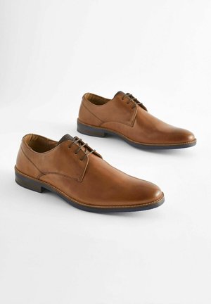 Brown leather shoes with a smooth finish, rounded toe, and lace-up design. Features a contrasting black textured accent on the collar.