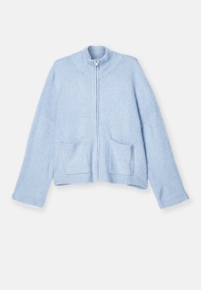 Svetlo modra zip-up jopica, mehka volnena mešanica, visok ovratnik, rebraste manšete, dve sprednji žepu, sproščen kroj in gladka tekstura.