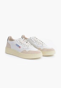 Coppia di sneakers basse in pelle bianca con dettagli in camoscio beige, perforazioni e logo laterale marchiato su suole in gomma beige chiaro.