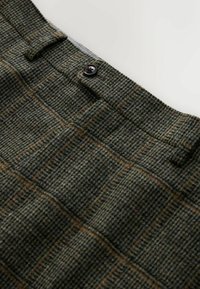 Hosen aus strukturiertem Wollstoff im karierten Muster in Grün und Braun. Mit Knopfverschluss, flachem Vorderteil und Seitentaschen.